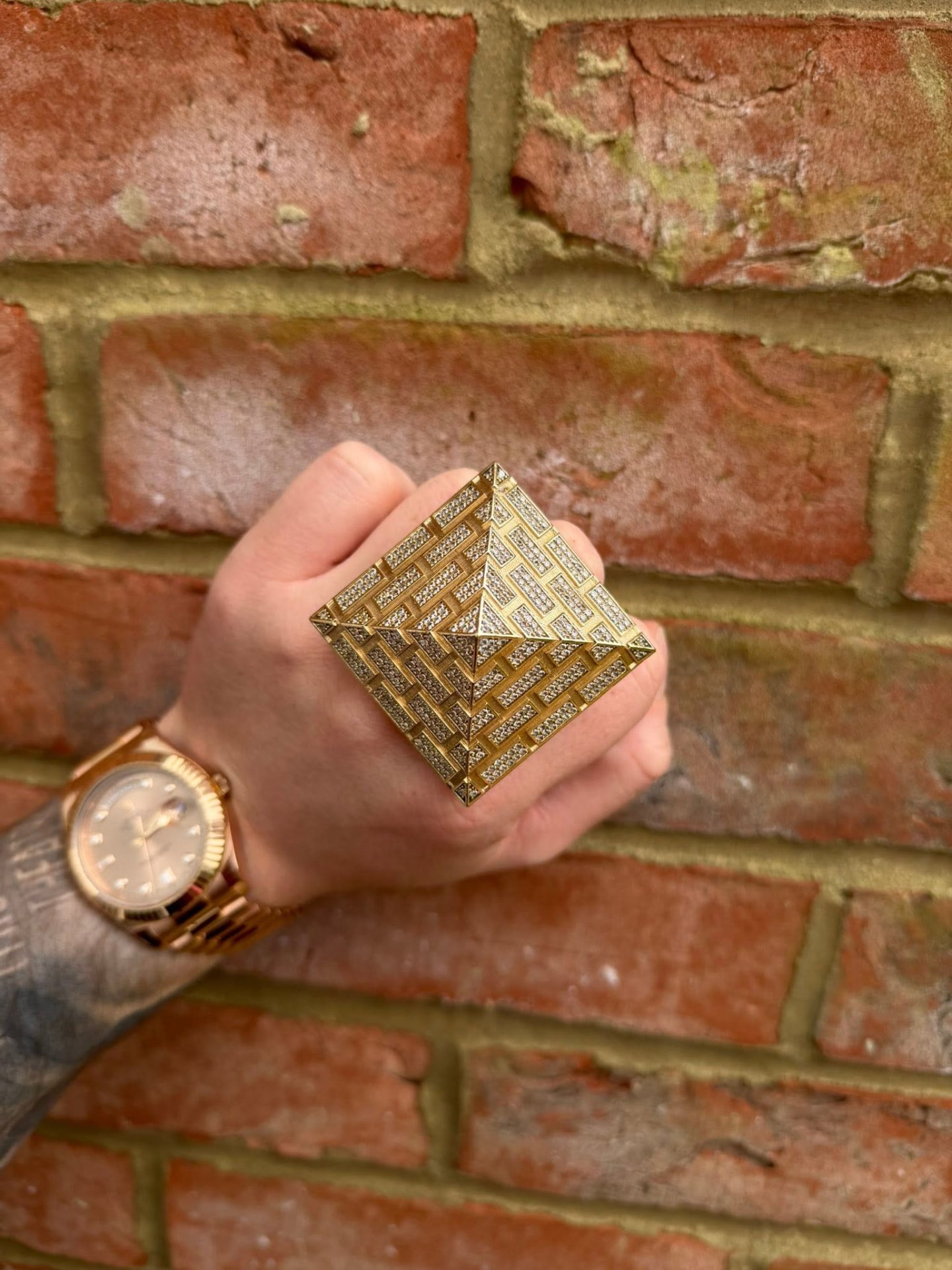 Large gold pyramid ring fully set with diamonds, worn on the hand