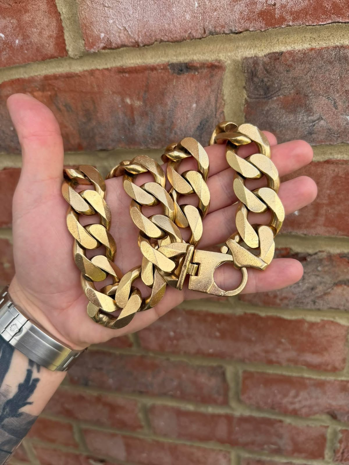 Wide gold curb chain with a satin finish and oversized clasp