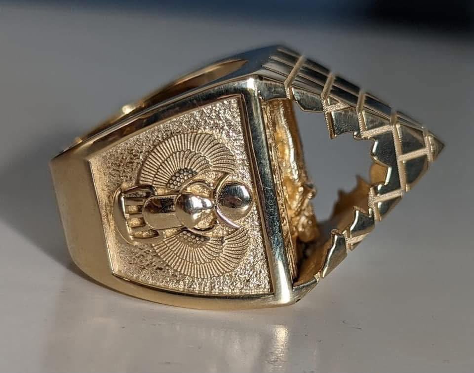 Detailed gold statement ring with an engraved buckle design